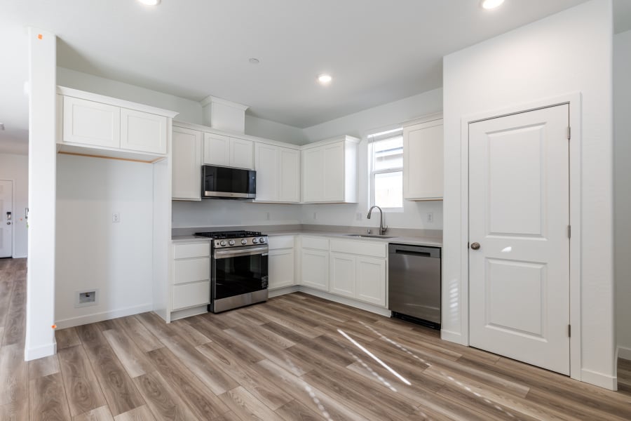 A kitchen with white cabinets.