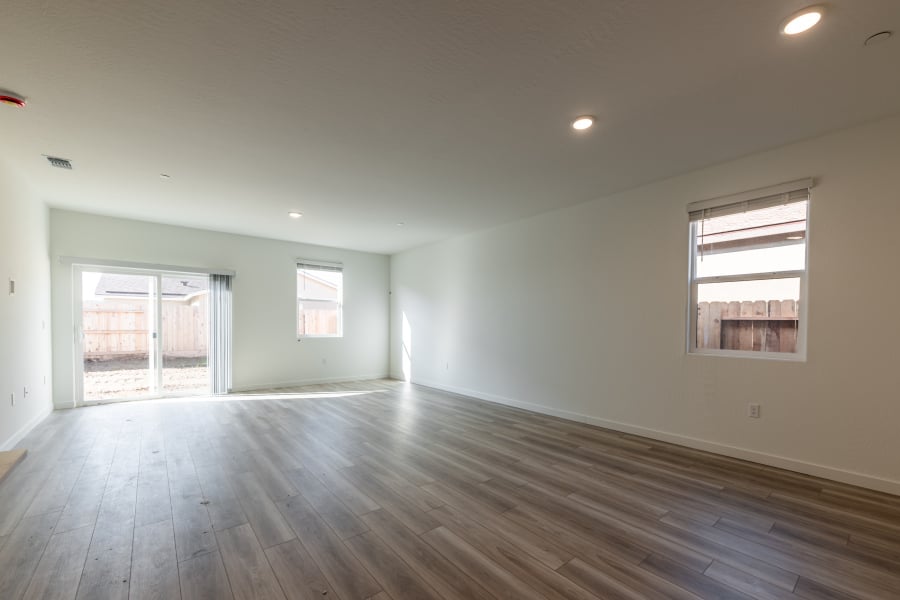 A room with a wood floor and windows.