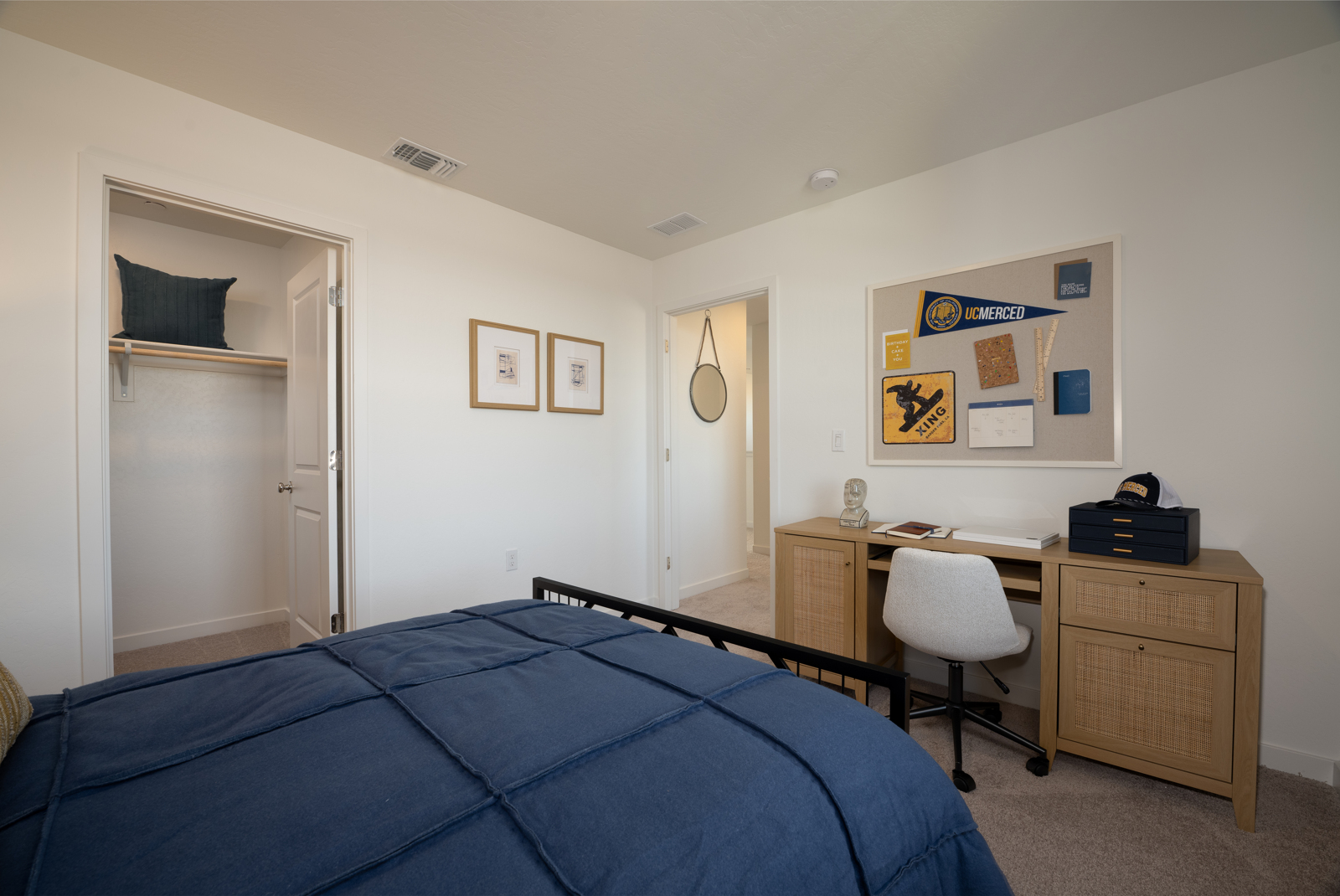 A bedroom with a bed desk and a chair.