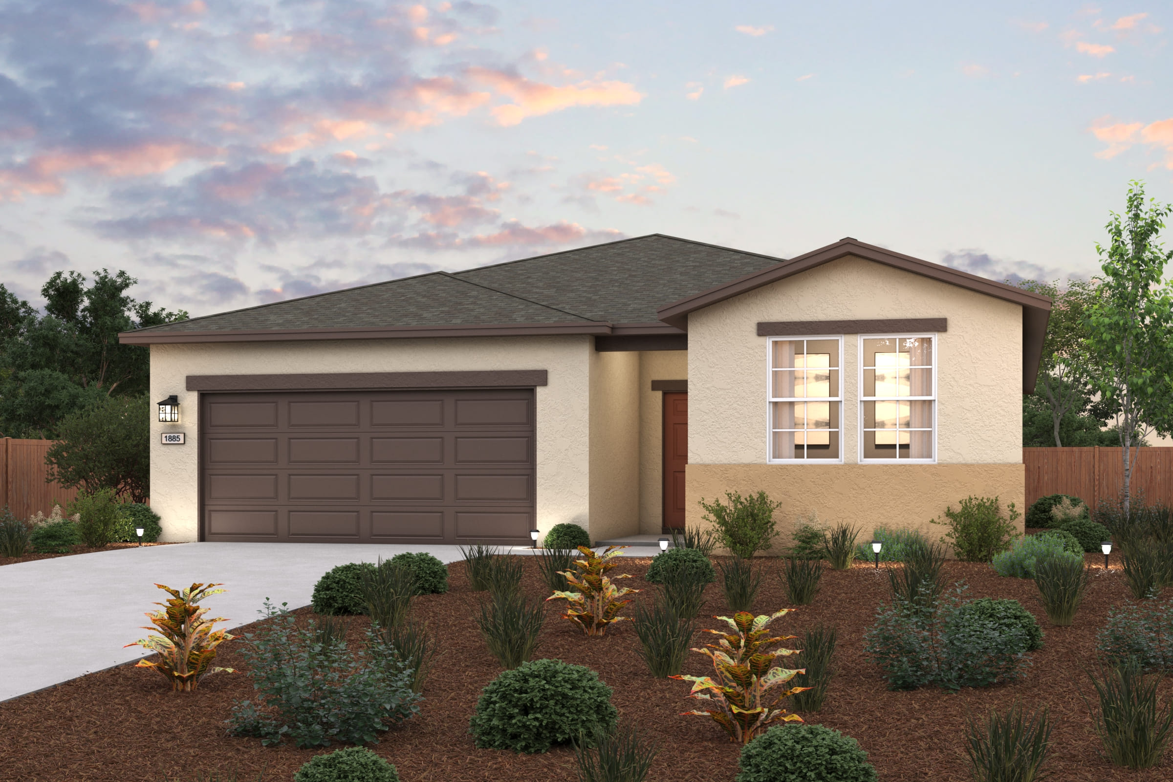 A house with a garage and bushes in front of it.