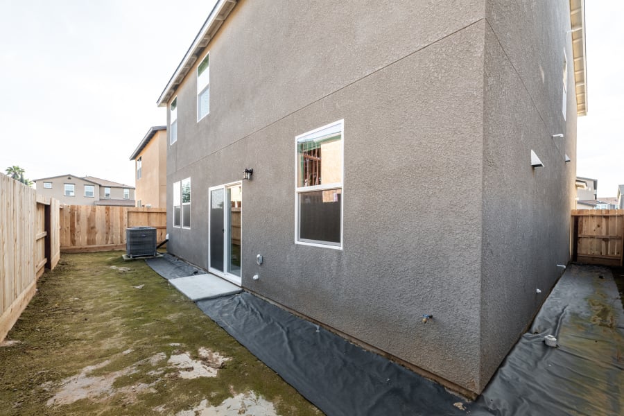 A grey building with a fence.