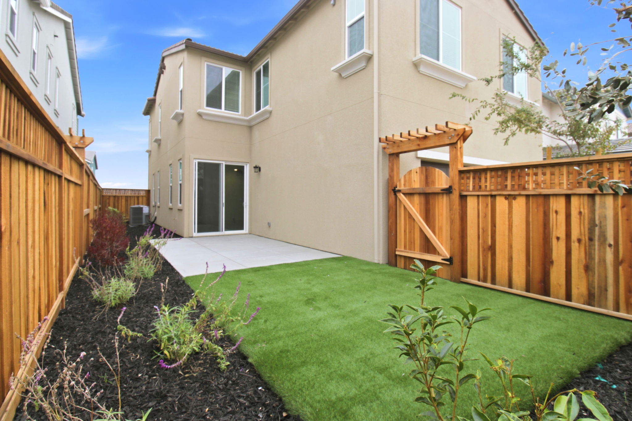 A backyard with a fence and a house.