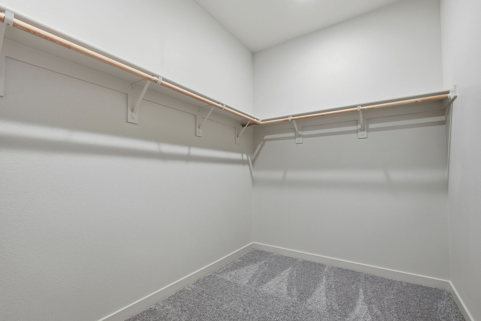 A white room with a grey carpet.