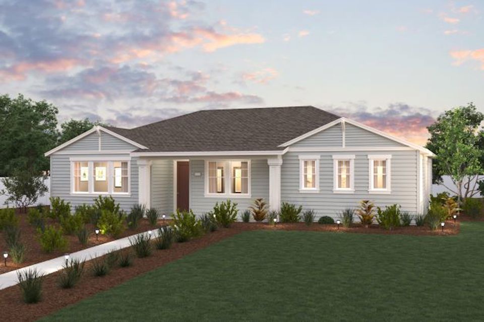 A house with a lawn and a fence in front of it.