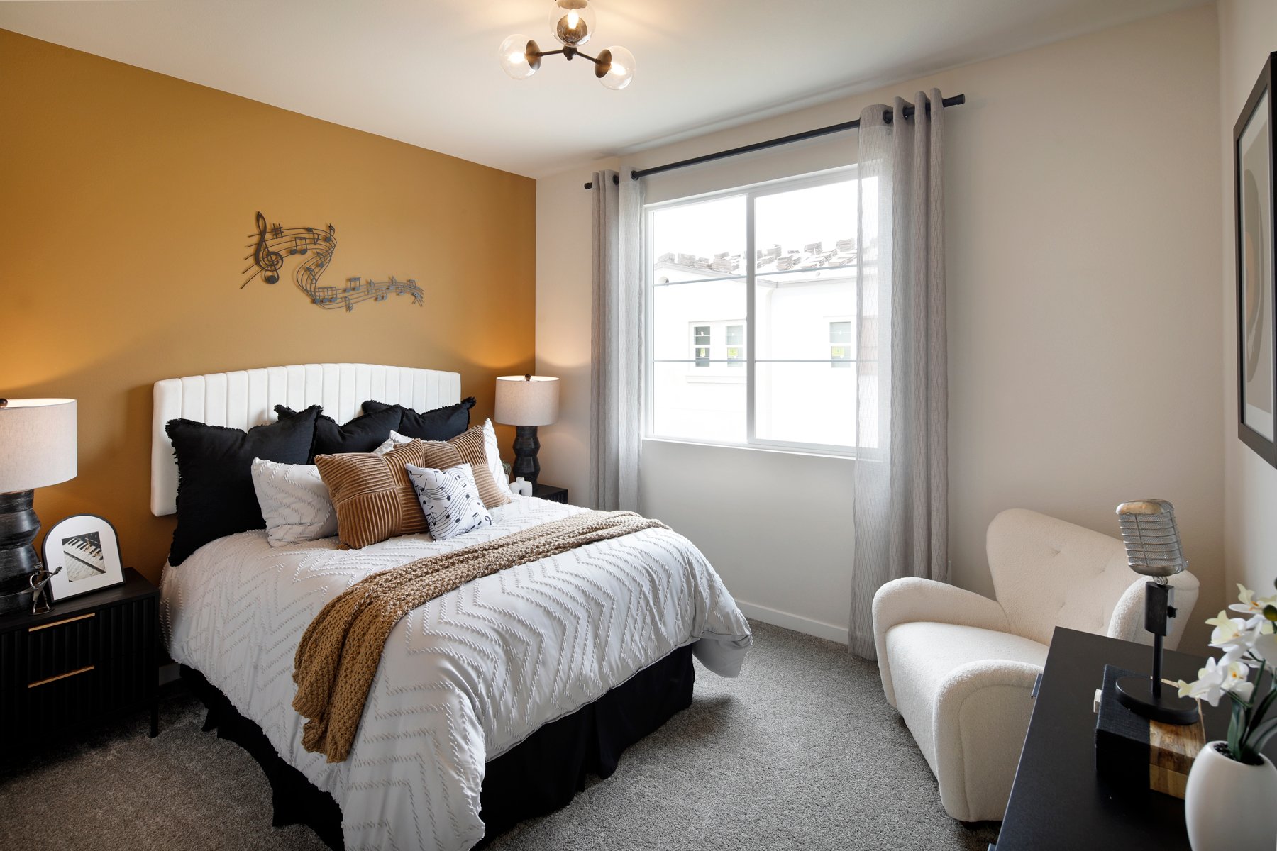 A bedroom with a bed and a chair.