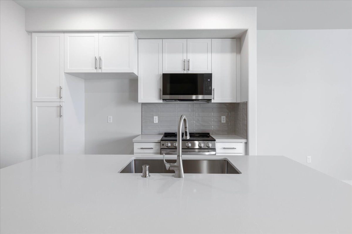 A kitchen with white cabinets.