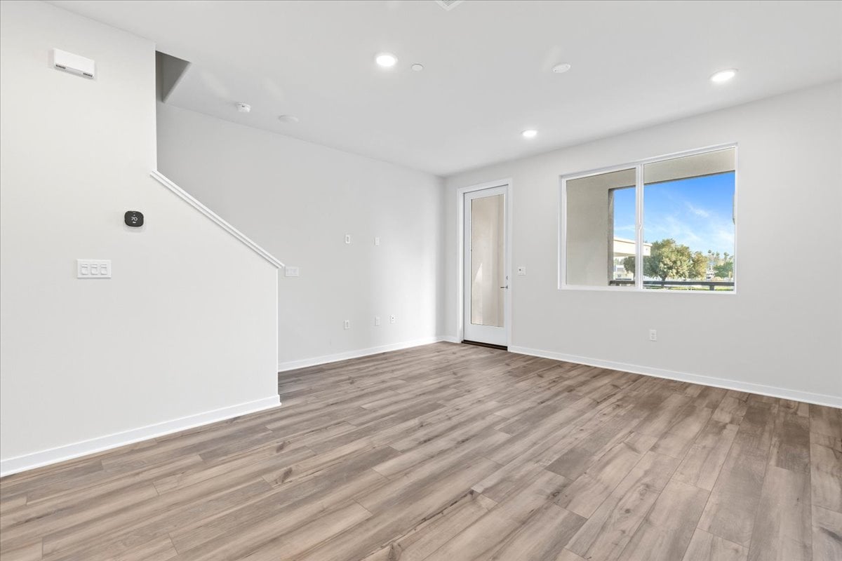 A room with a wood floor and a window.