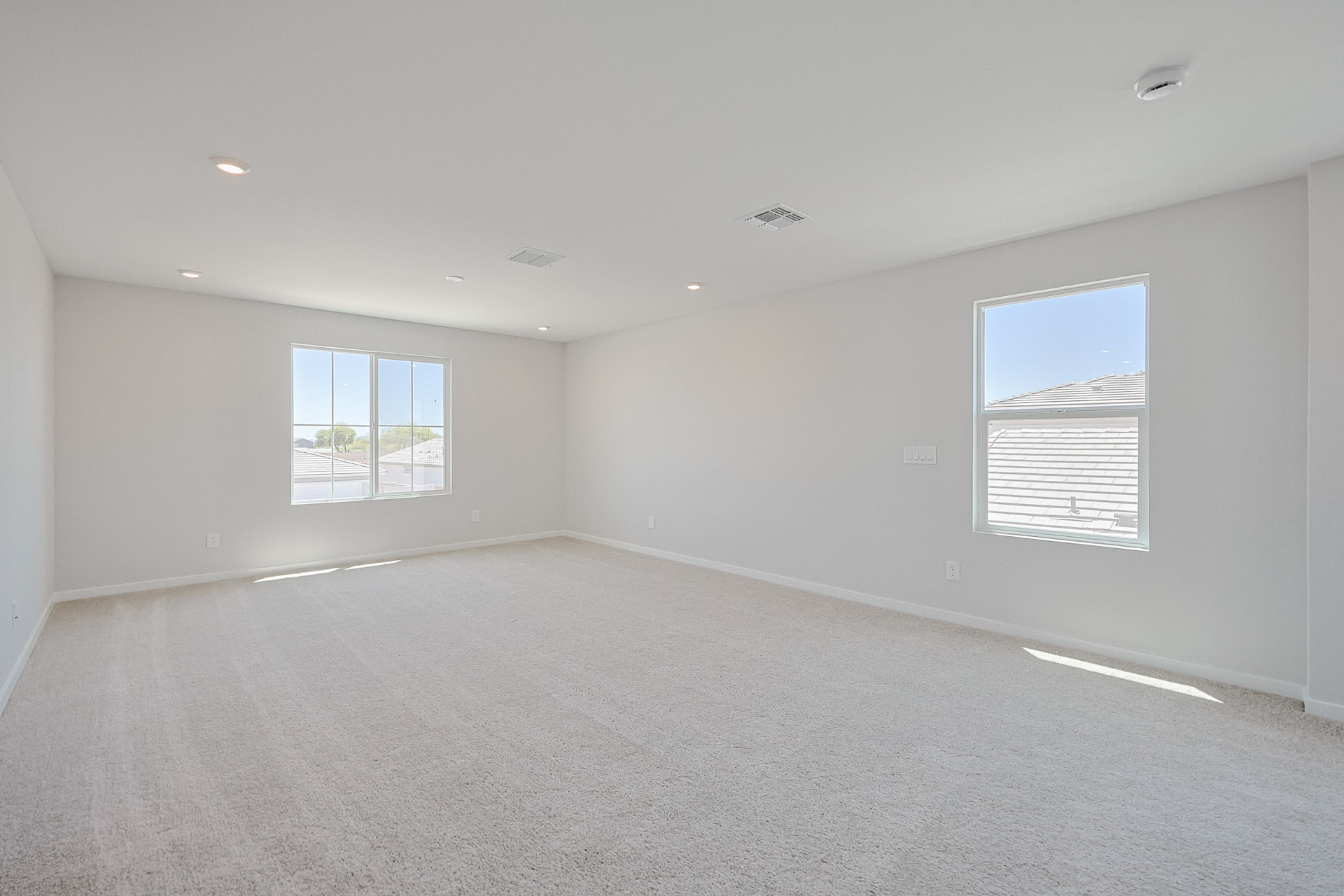 A room with a white wall and windows.