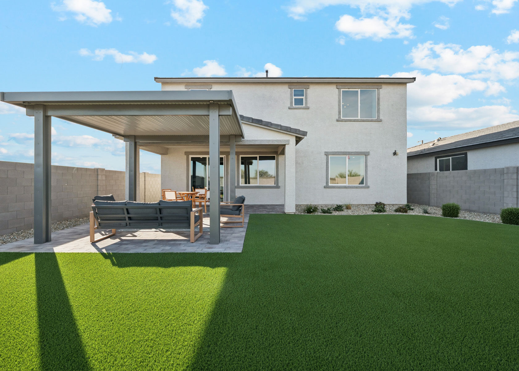 A house with a patio and a table and chairs in the front.