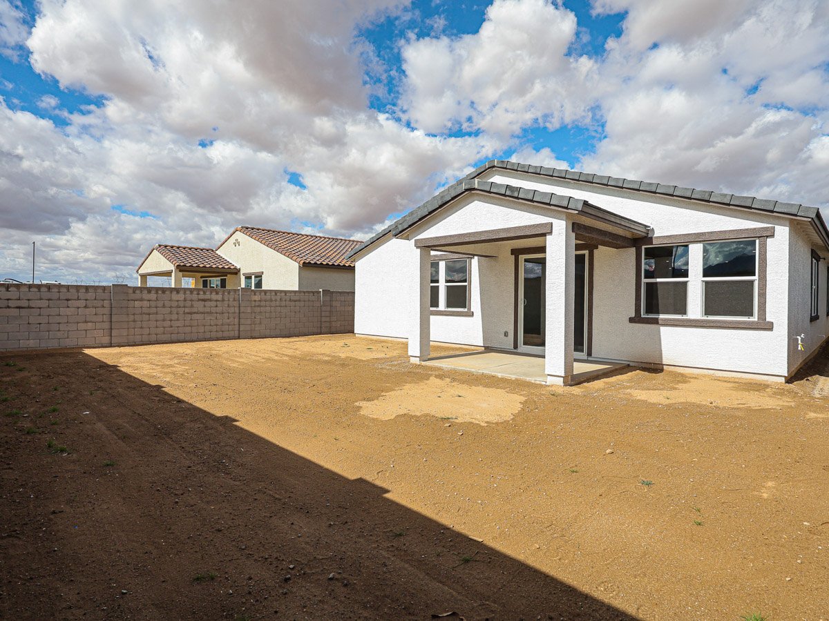A dirt road leading to a house.