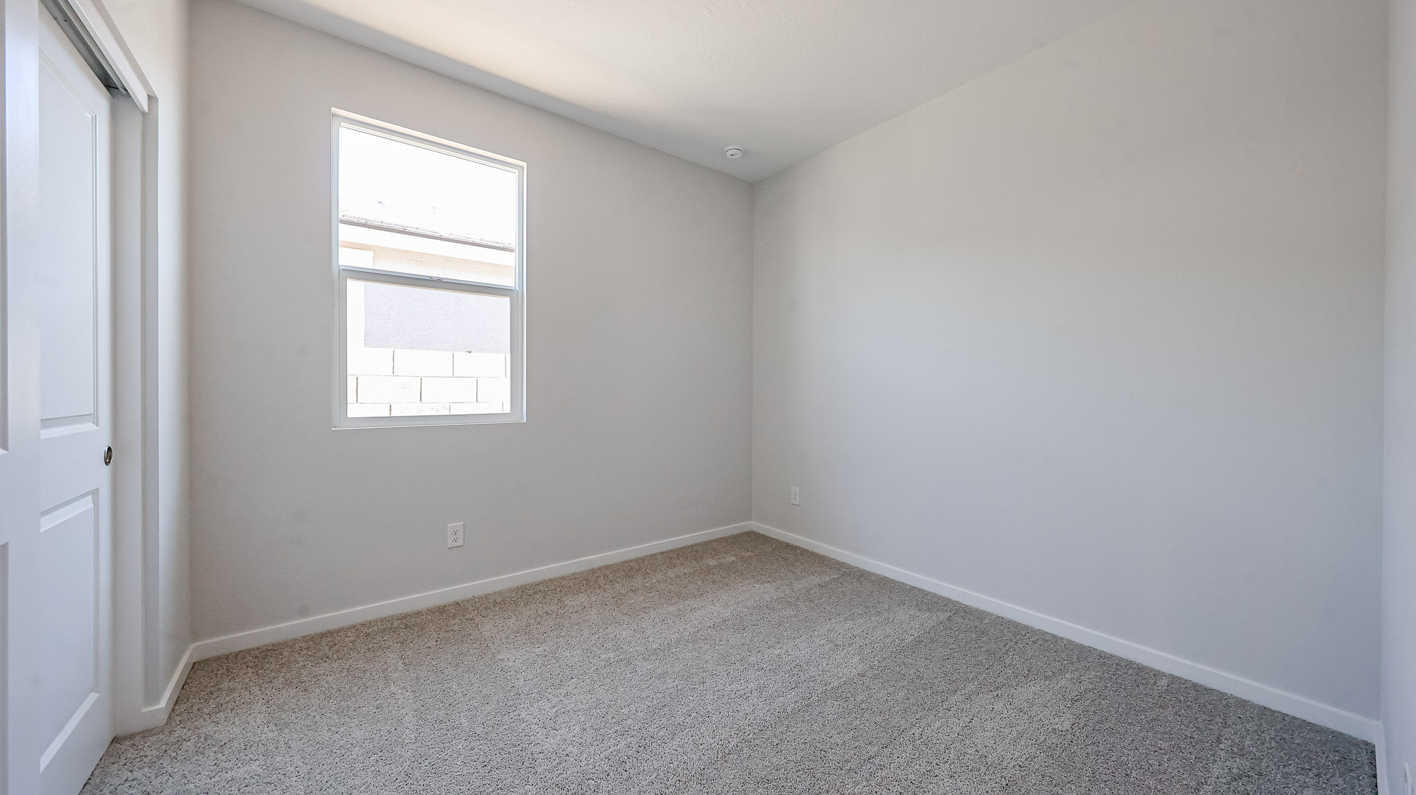 A room with a window and carpet.