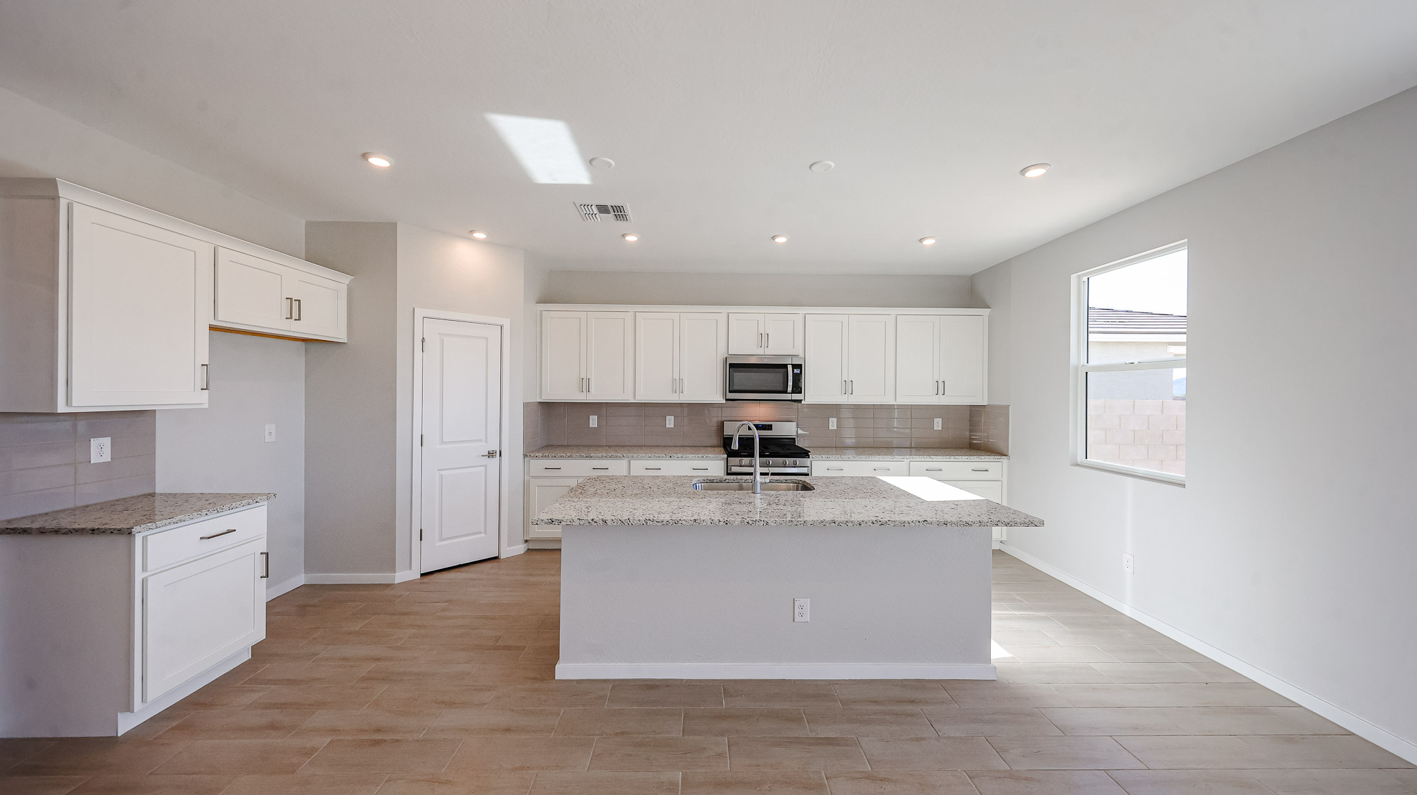 A kitchen with white cabinets.