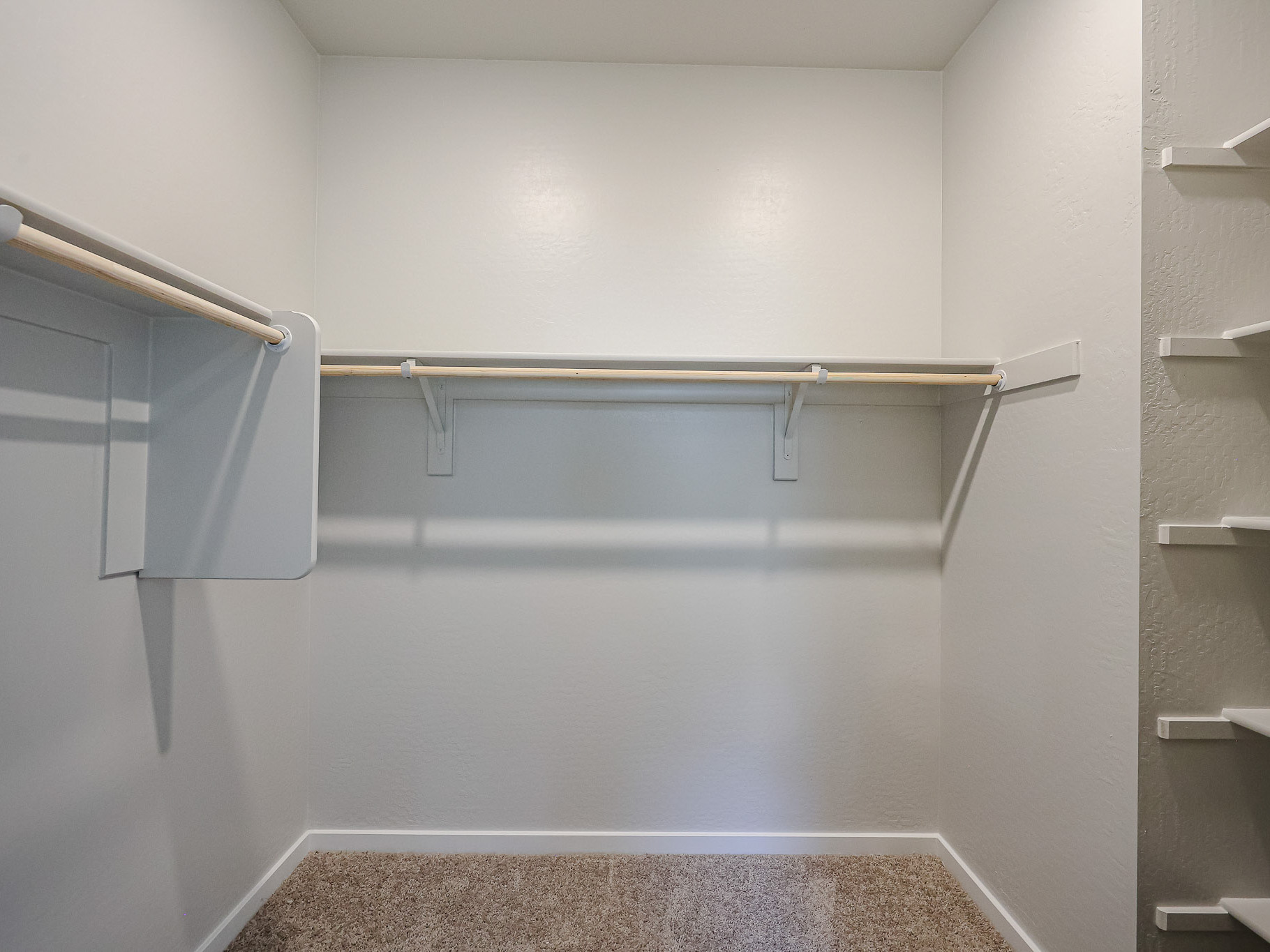 A white wall with a metal bar.