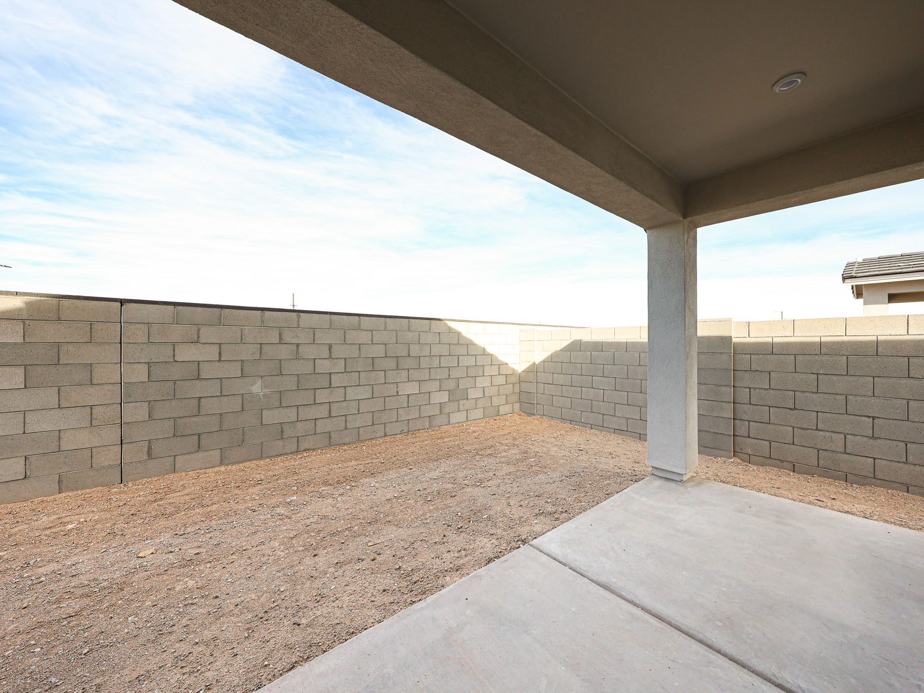 A concrete wall with a cement walkway.