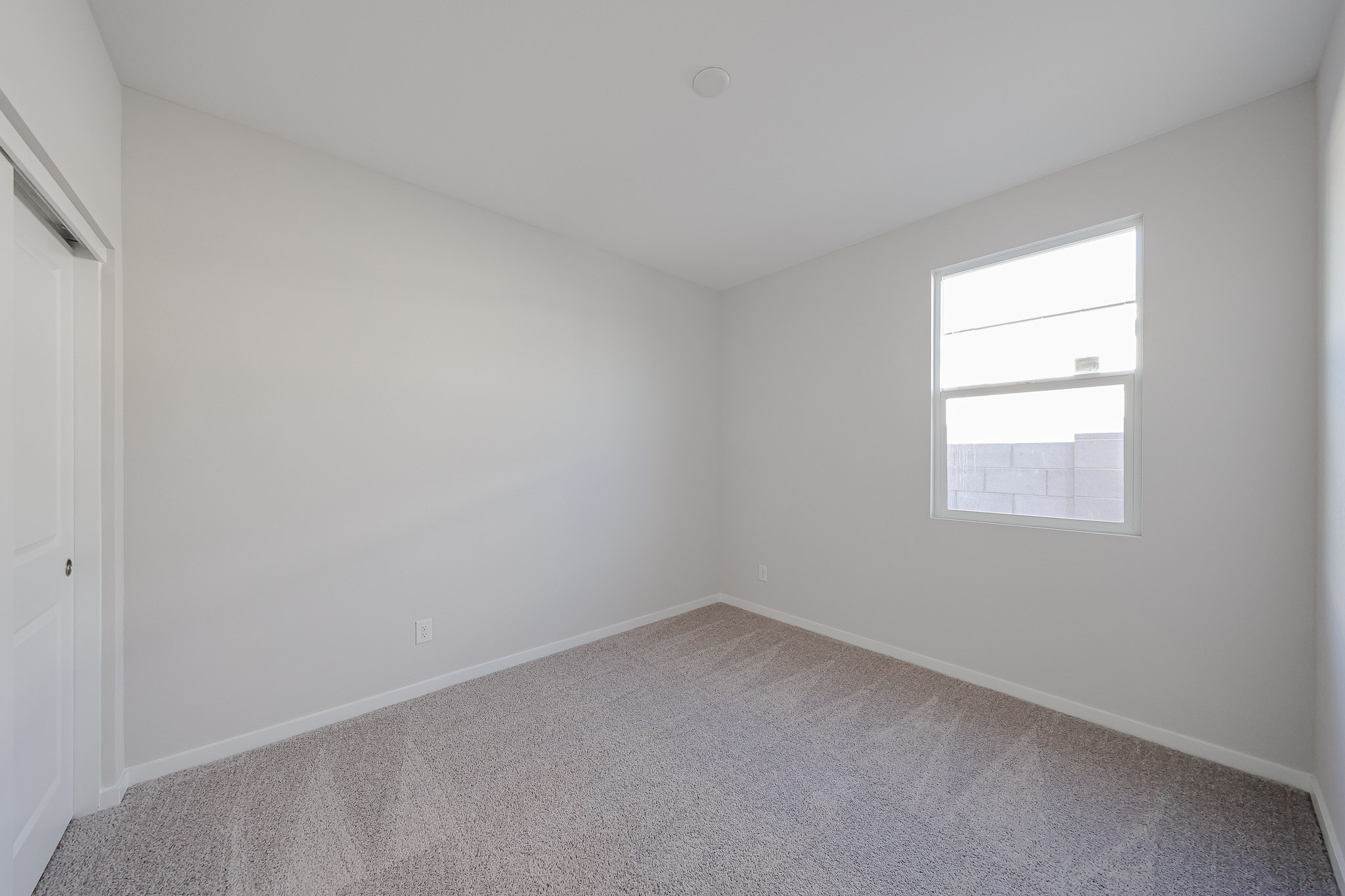 A room with a window and carpet.
