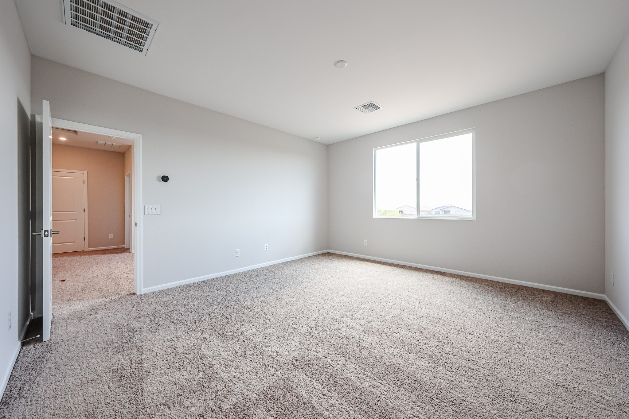 A room with a carpet and a door.