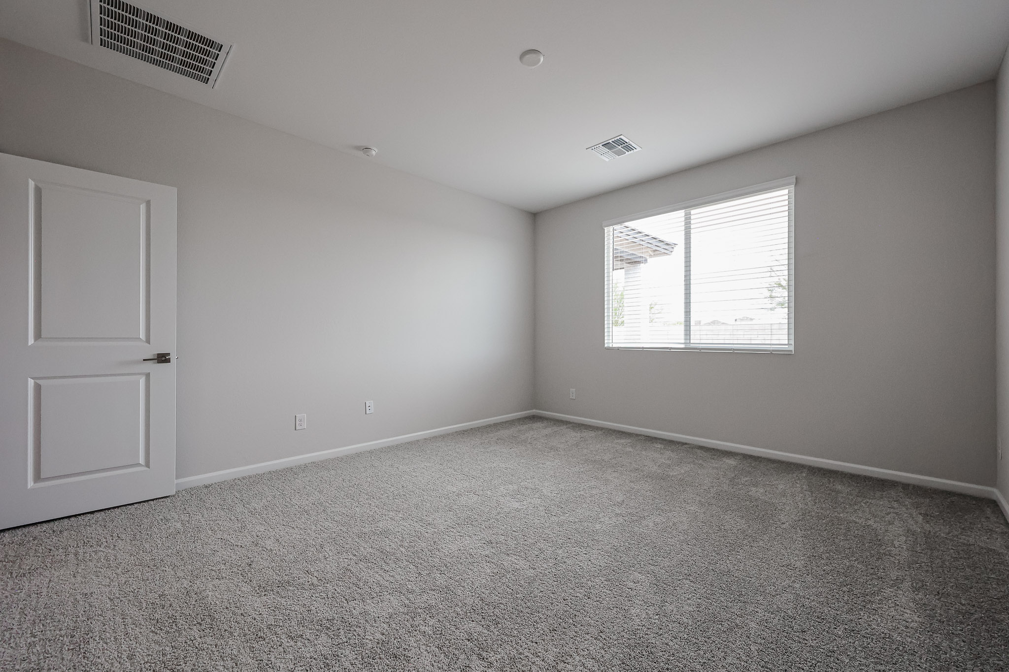 A room with a carpet and a door.