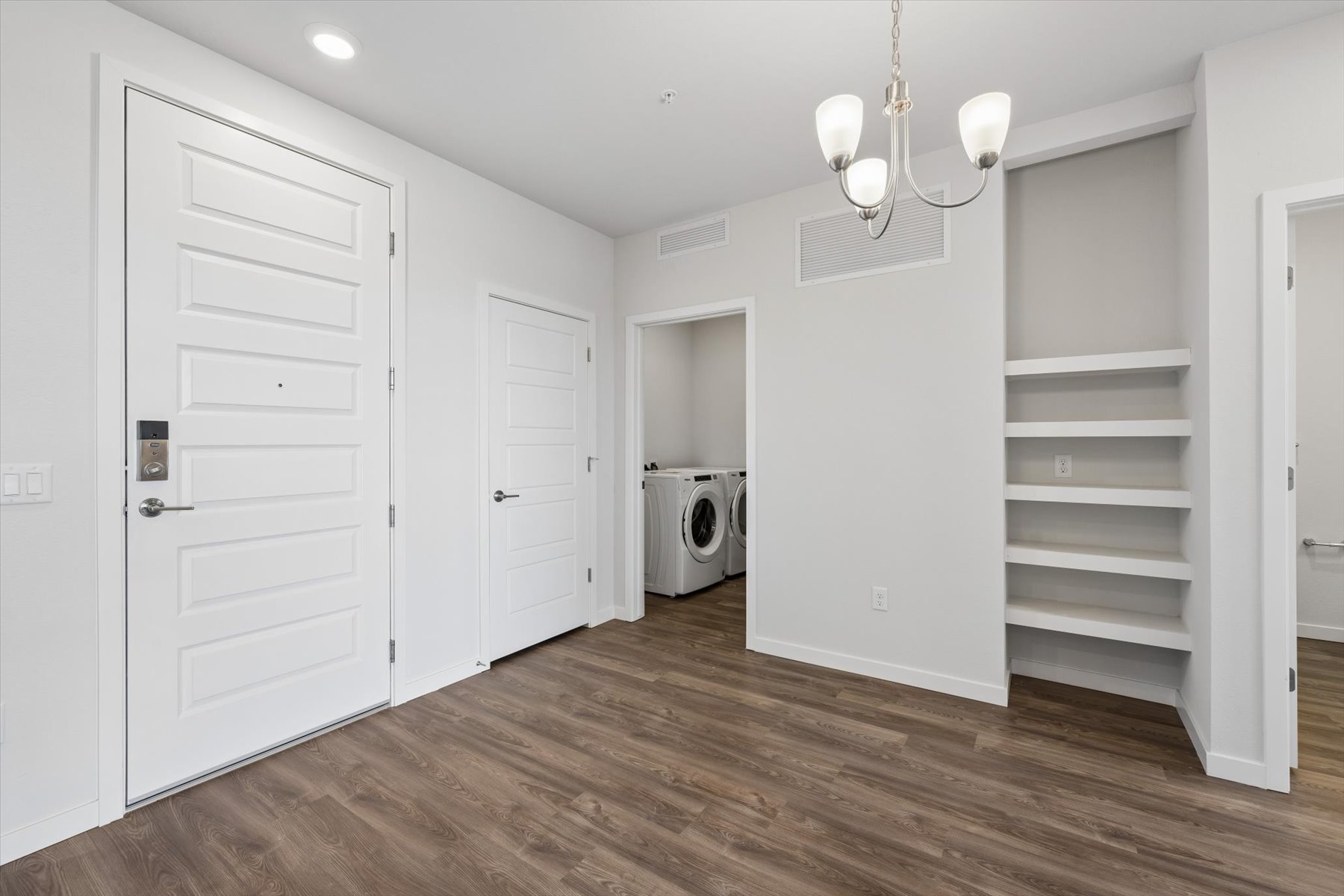 A room with white cabinets and a white door.