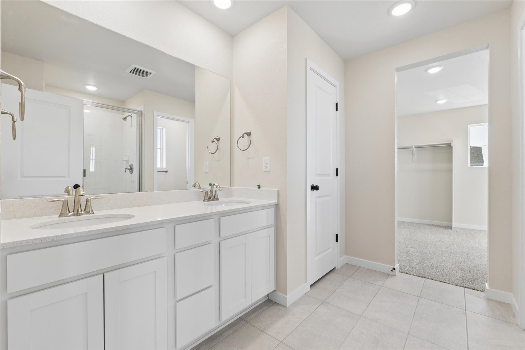 A bathroom with white cabinets.