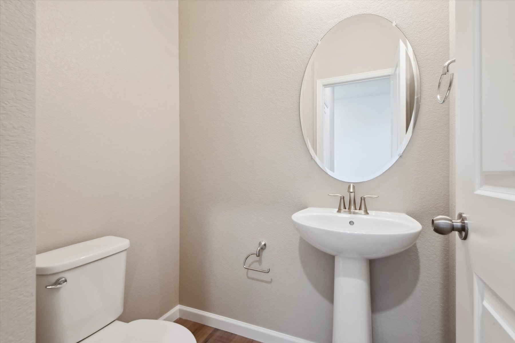 A bathroom with a round mirror.