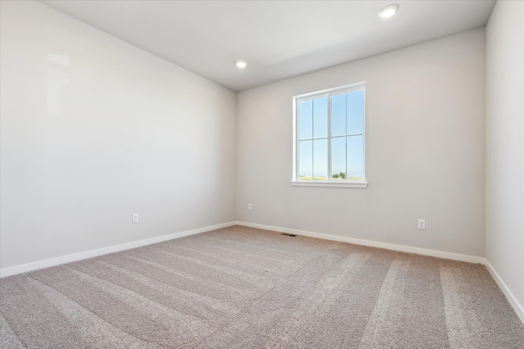 A room with a window and carpet.
