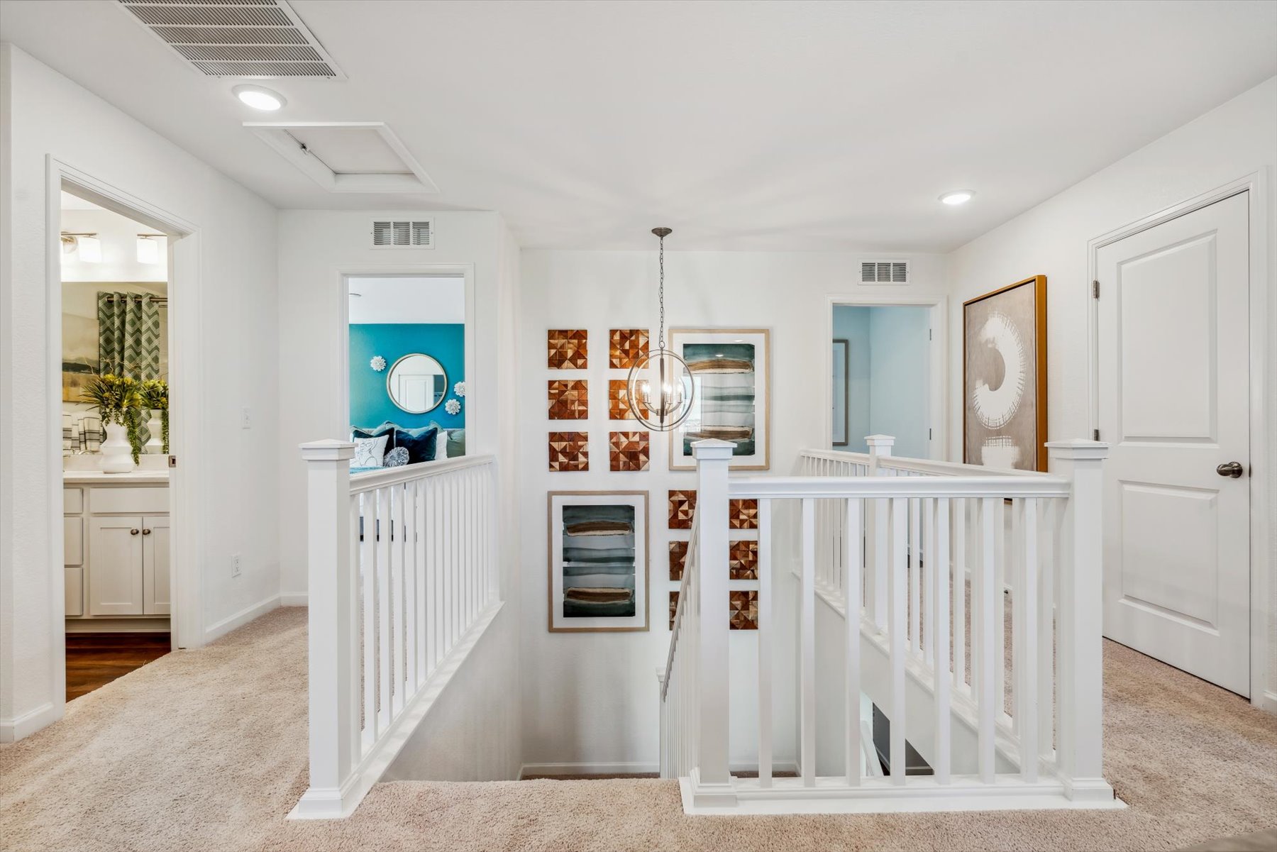 A white room with a white crib and a white railing.