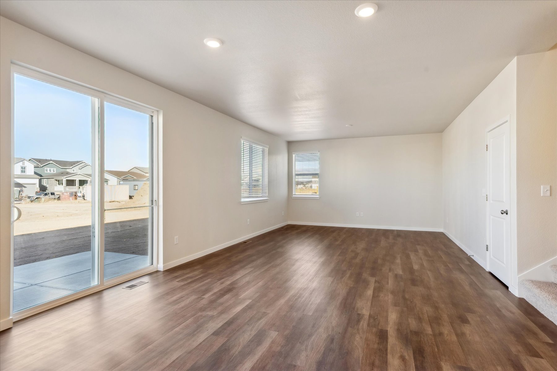 A room with a wood floor and a large window.