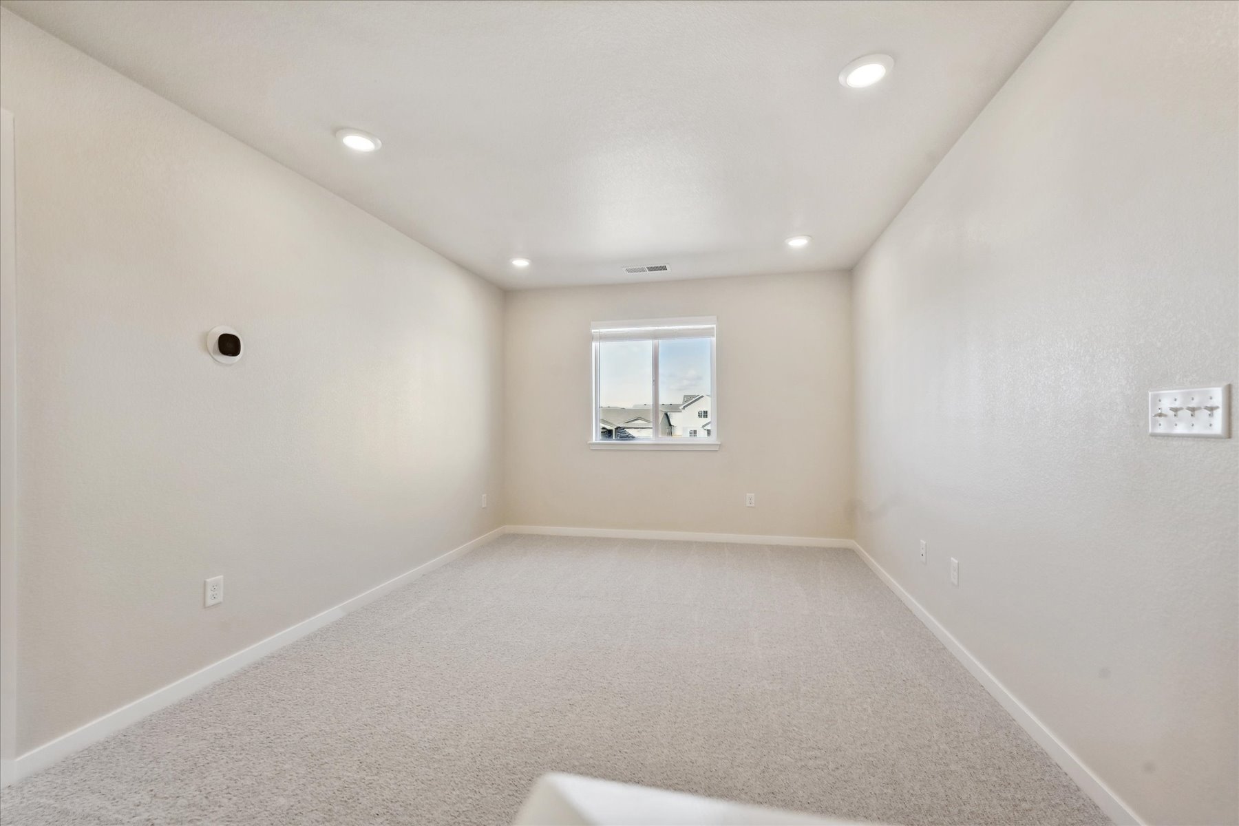 A room with a window and a white floor.