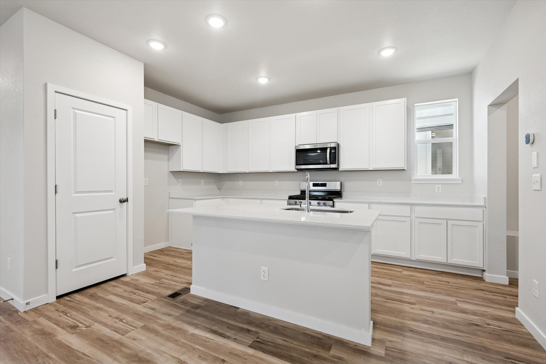 A kitchen with white cabinets.