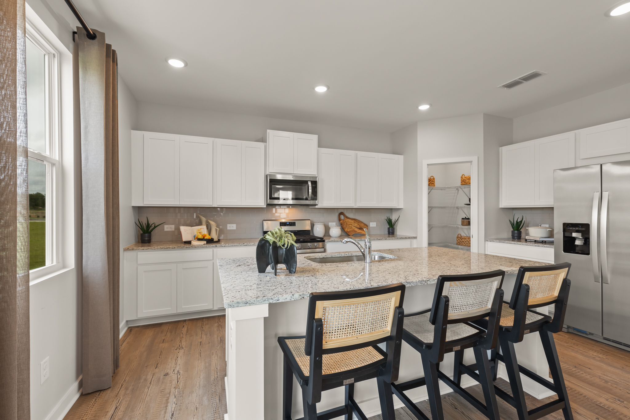 A kitchen with white cabinets.
