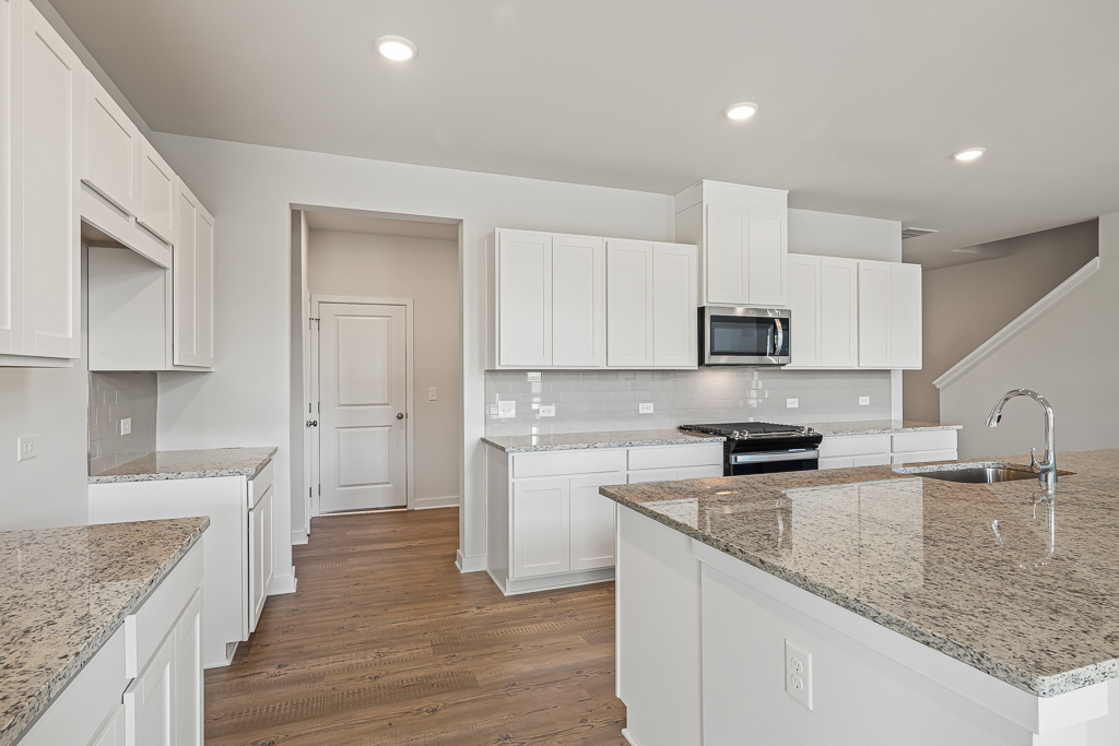 A kitchen with white cabinets.