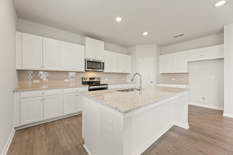 A kitchen with white cabinets.