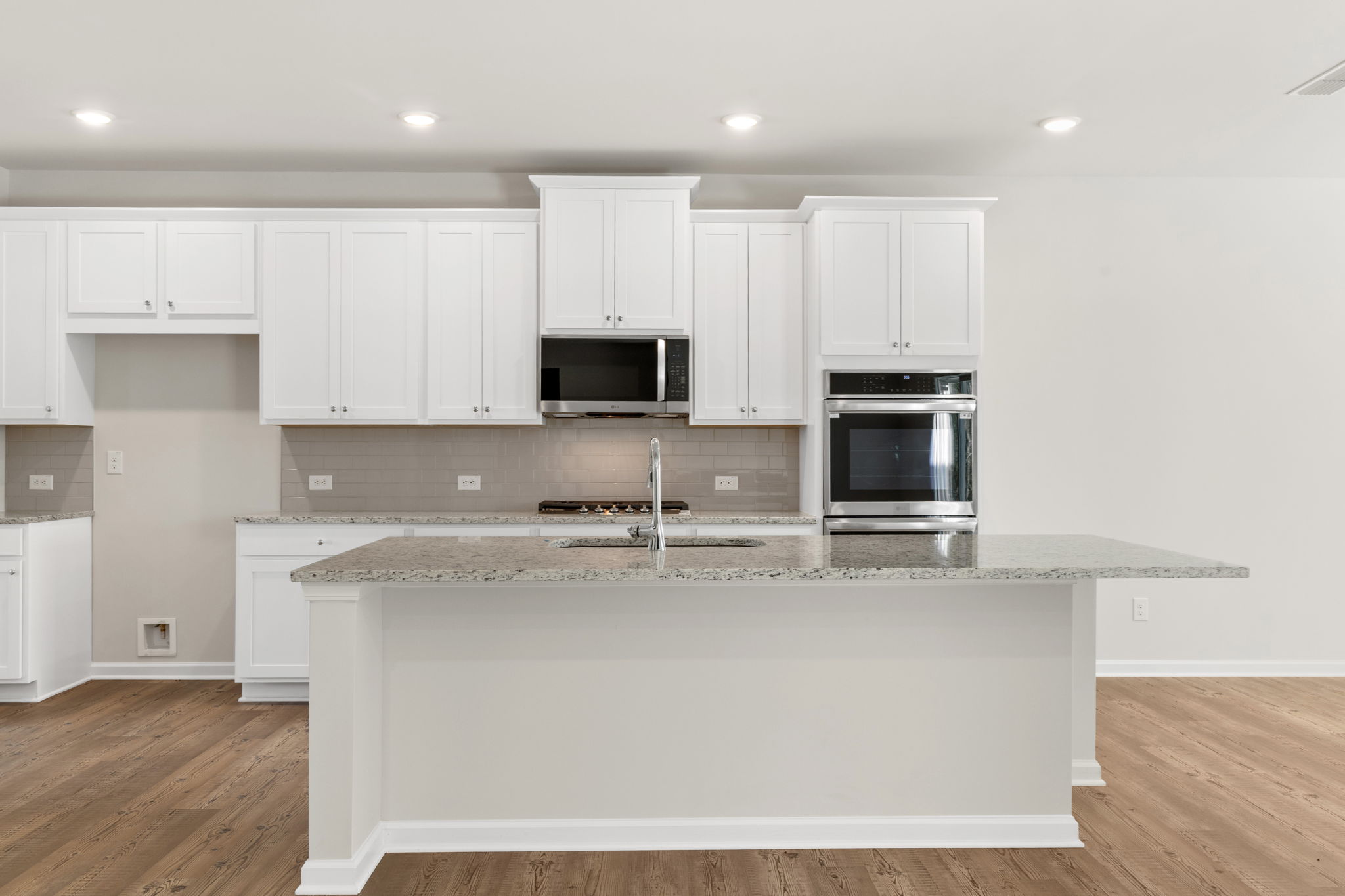 A kitchen with white cabinets.