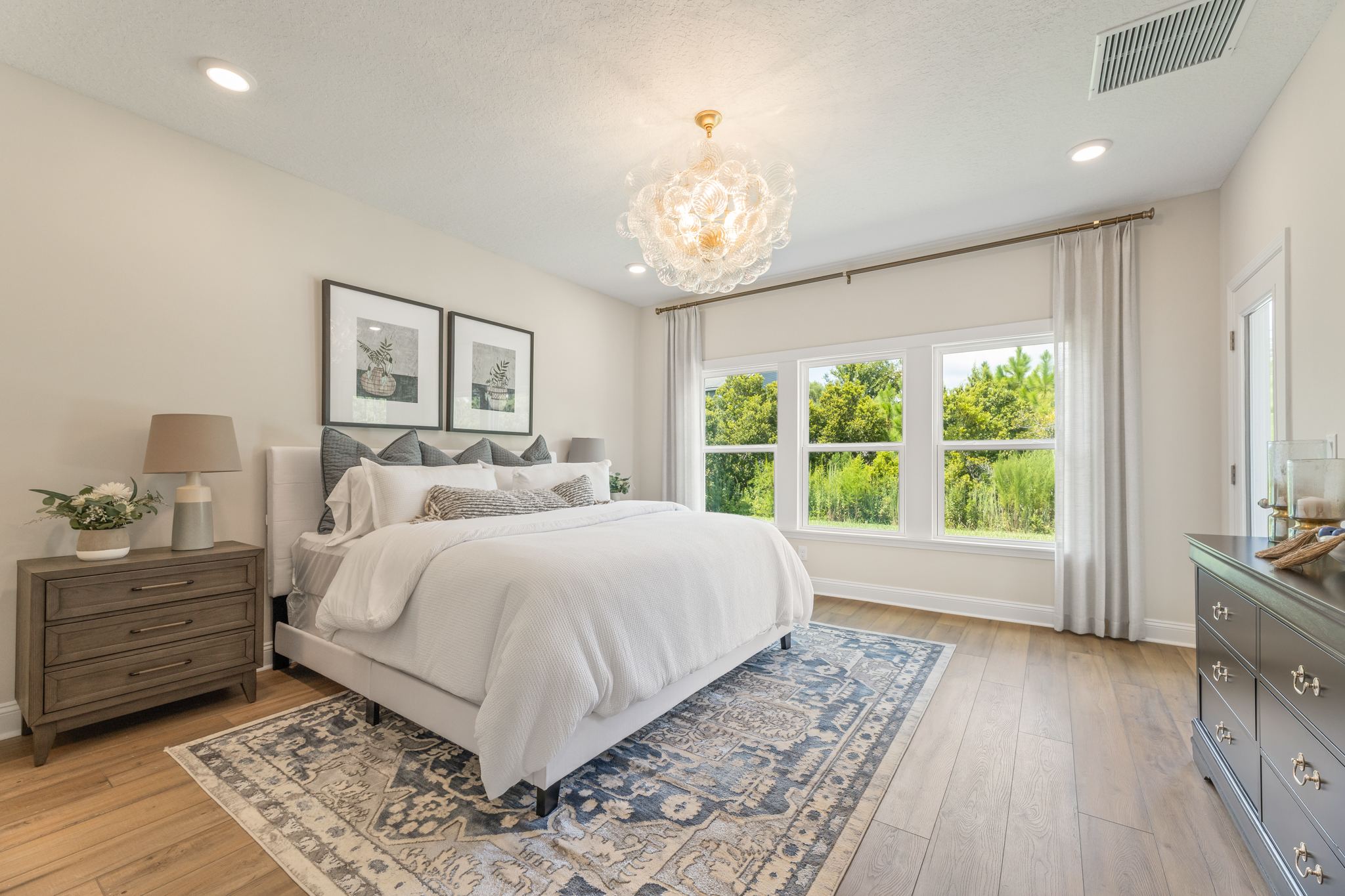 A bedroom with a bed and a chandelier.