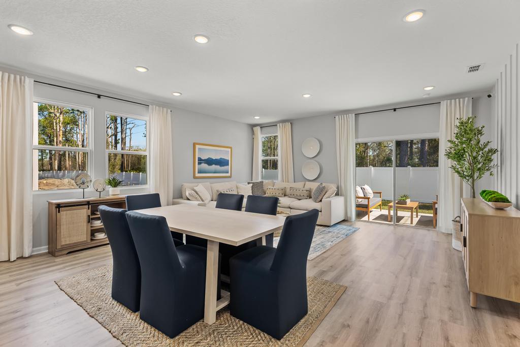 A large living room with a large table and chairs.