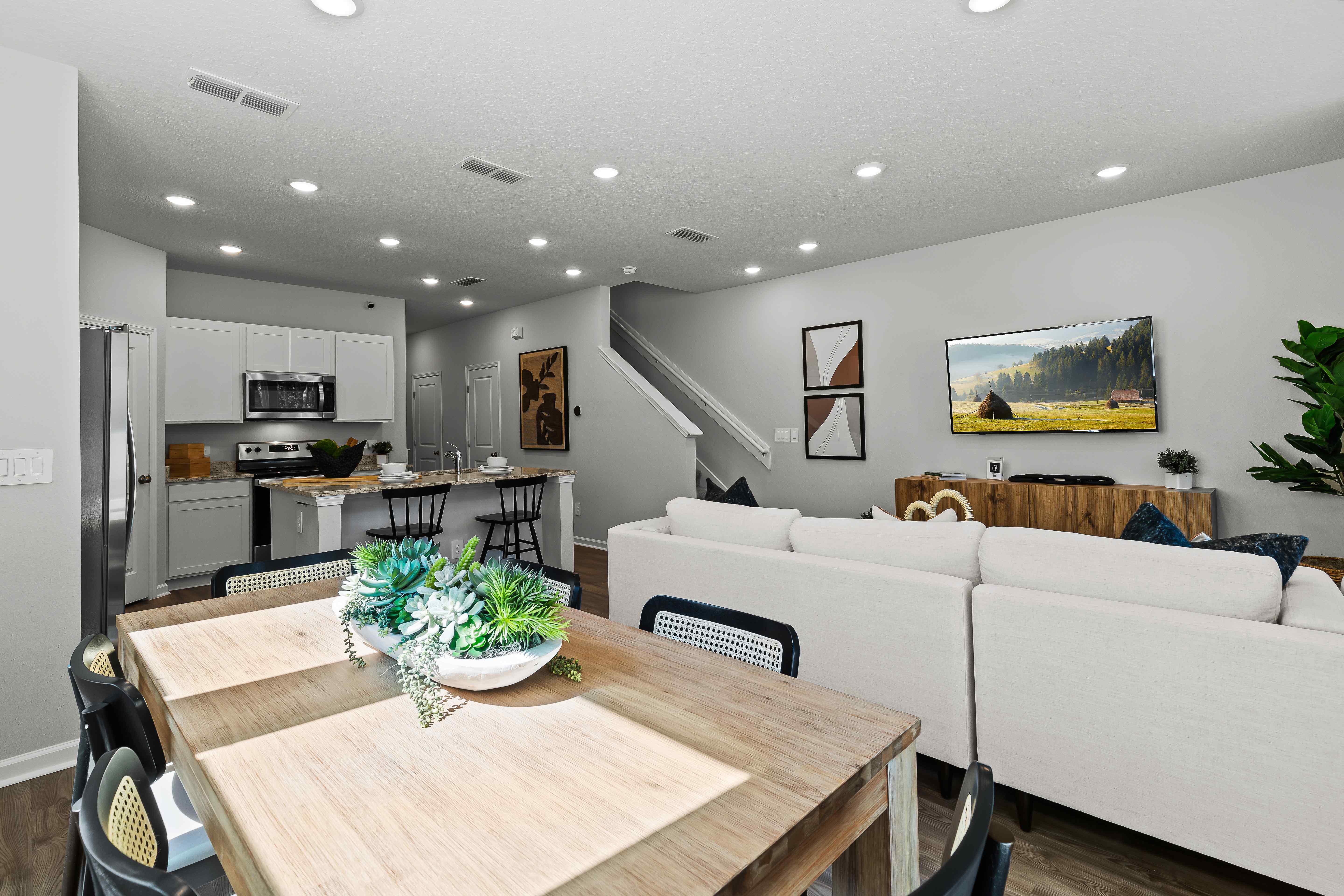 Davor Model Paired Home Wood Dining Table with Black Chairs Overlooking Kitchen The Landings at Pecan Park