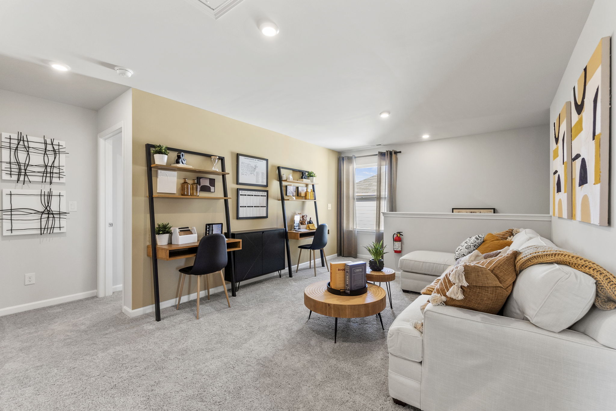 A living room with a desk and a chair.