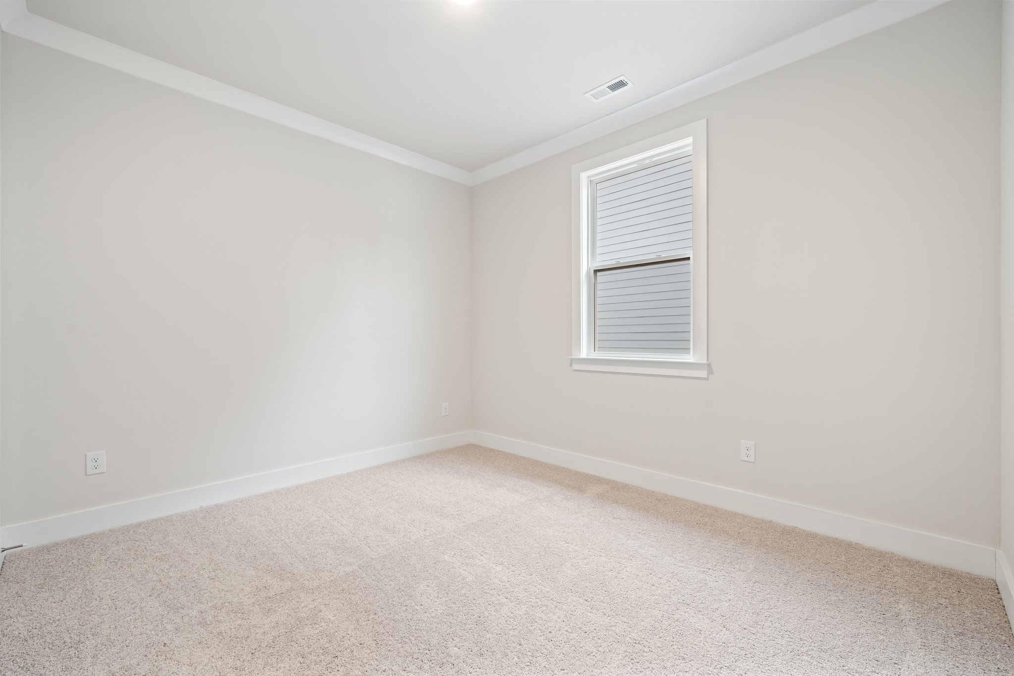 A room with a window and carpet.