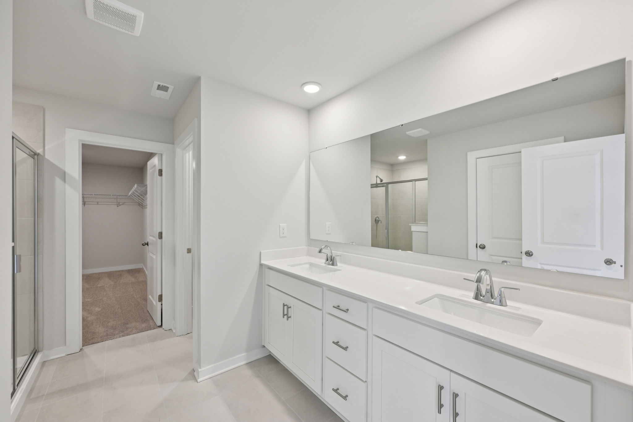 A bathroom with white cabinets.