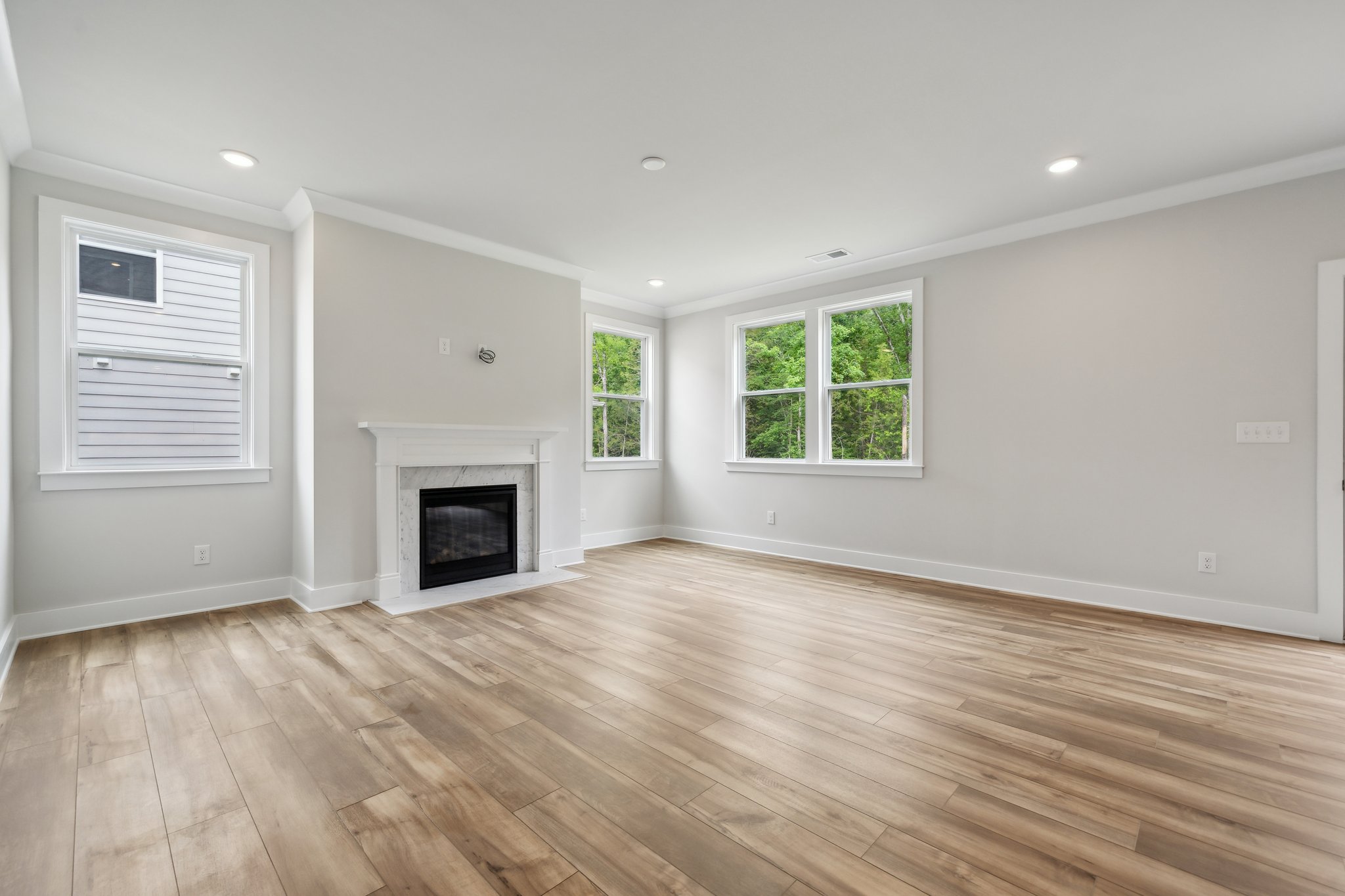 A room with a fireplace and a wood floor.