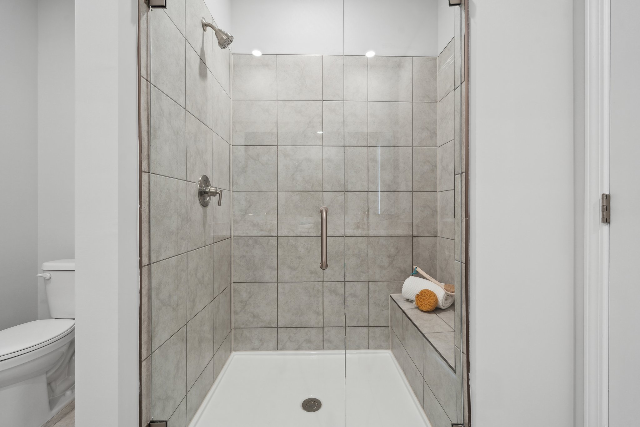 A bathroom with a shower unit and toilet.