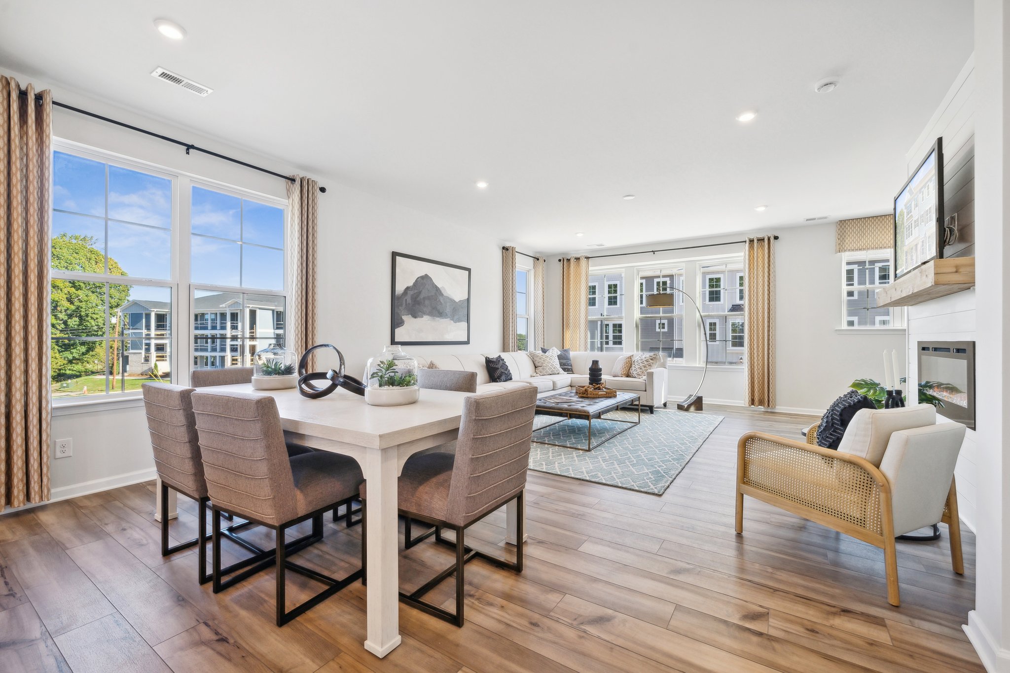 A large living room with a large dining table and a large window.