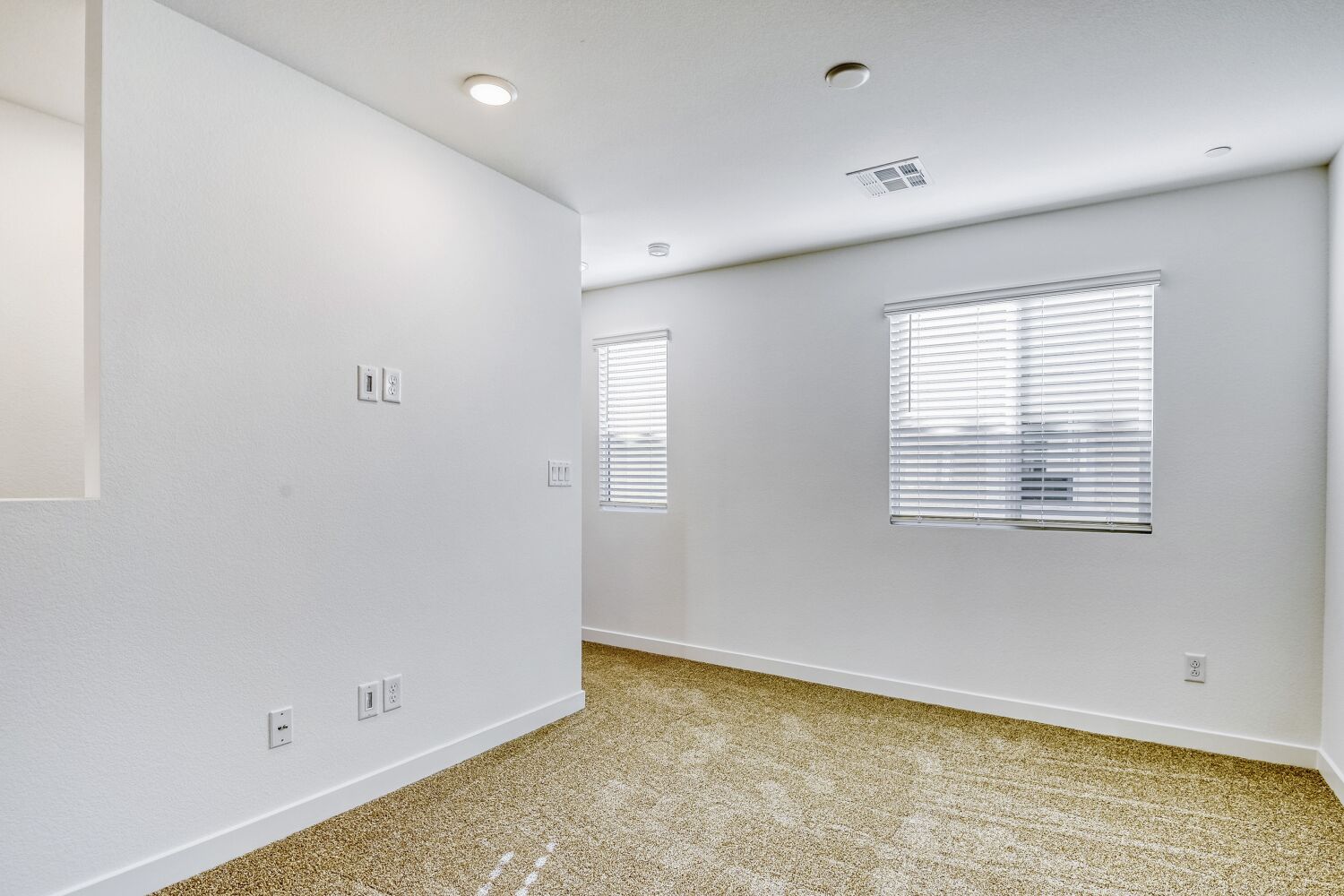 A room with a couple of white walls and a window.