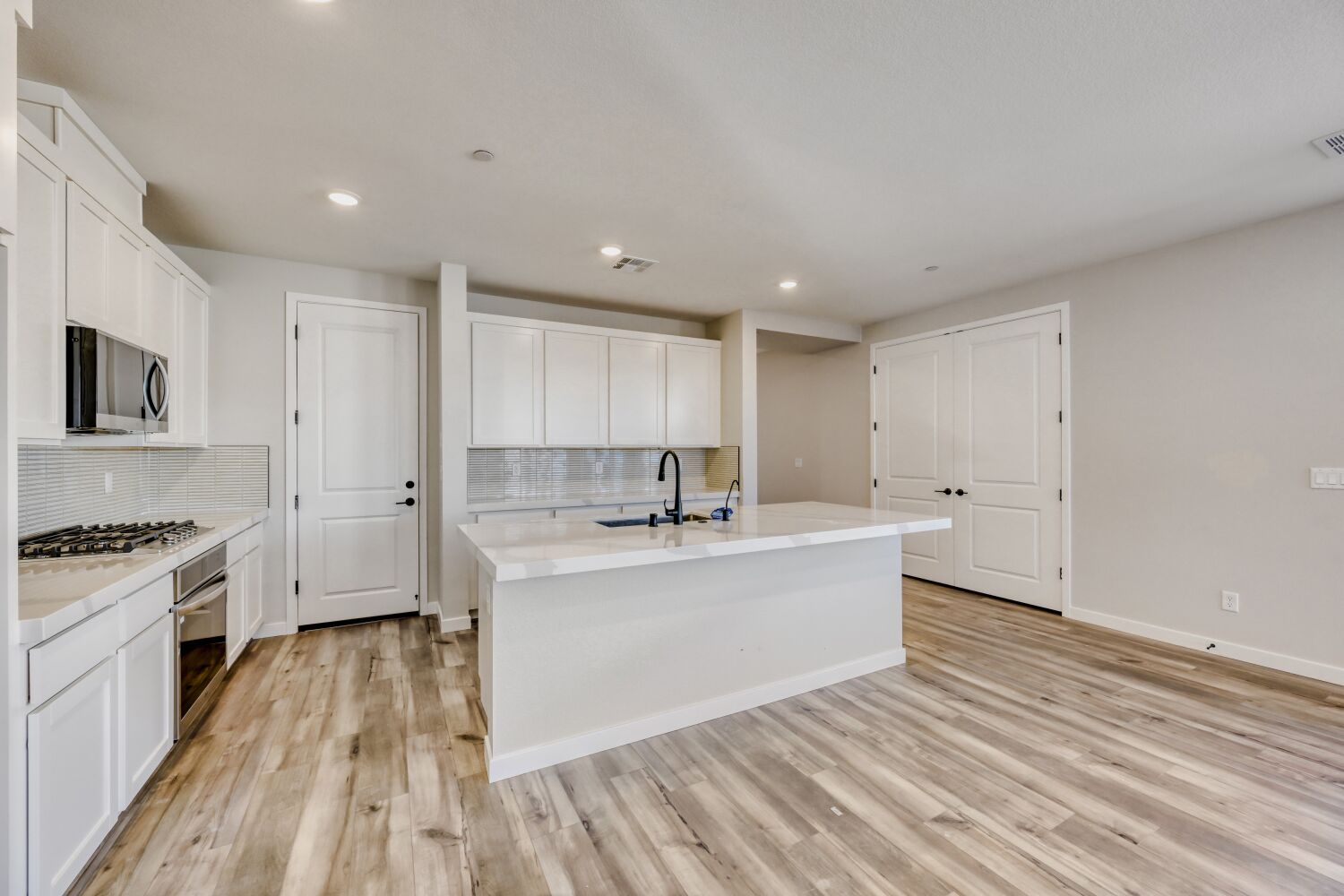 A kitchen with white cabinets.