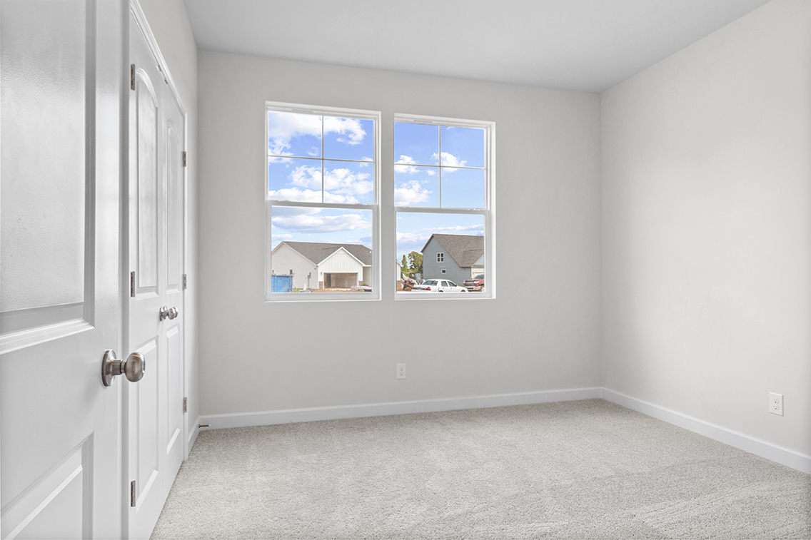 A room with a window and a carpet.