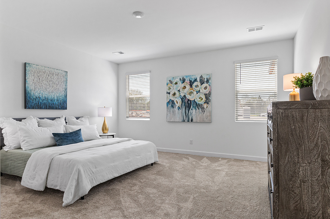 A bedroom with a bed and a lamp.