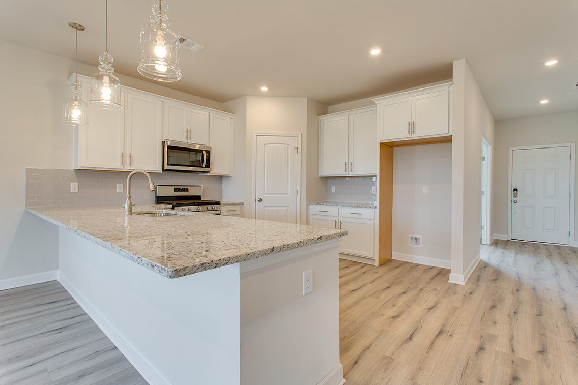 A kitchen with white cabinets.