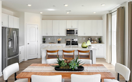 A kitchen with white cabinets.