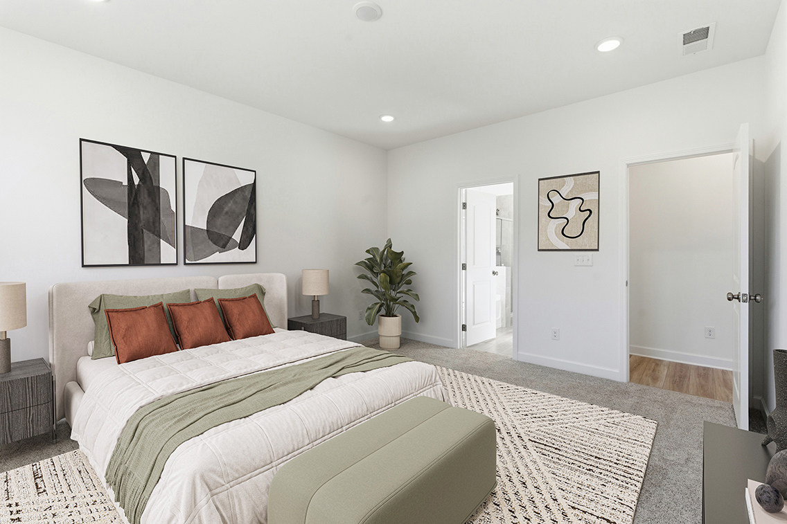 A bedroom with a bed and a plant on the side.