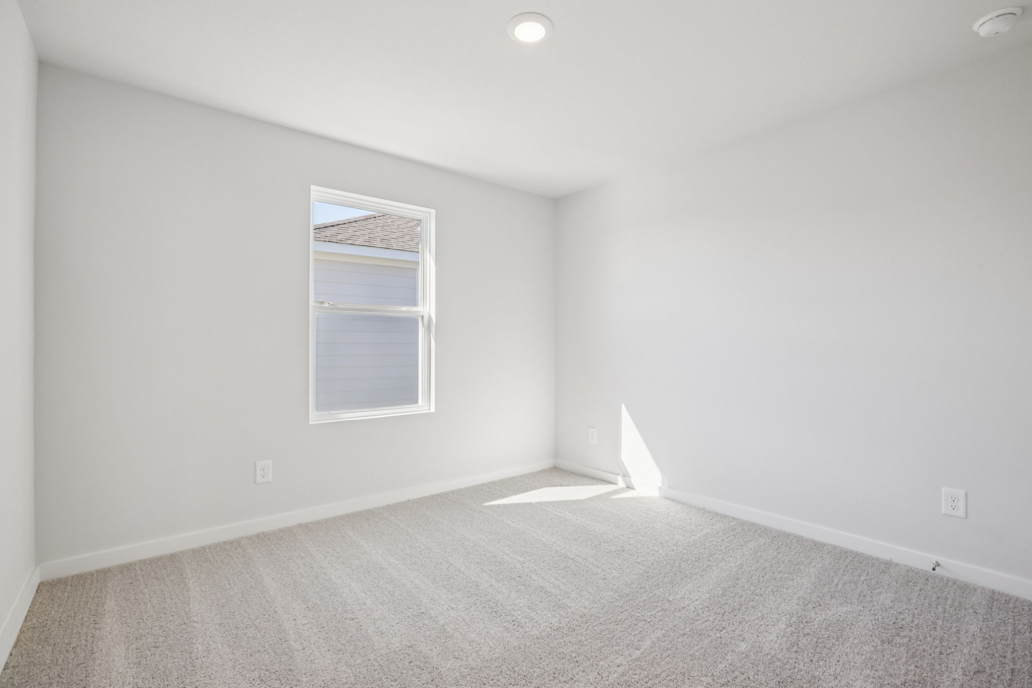 A room with a window and a carpet.